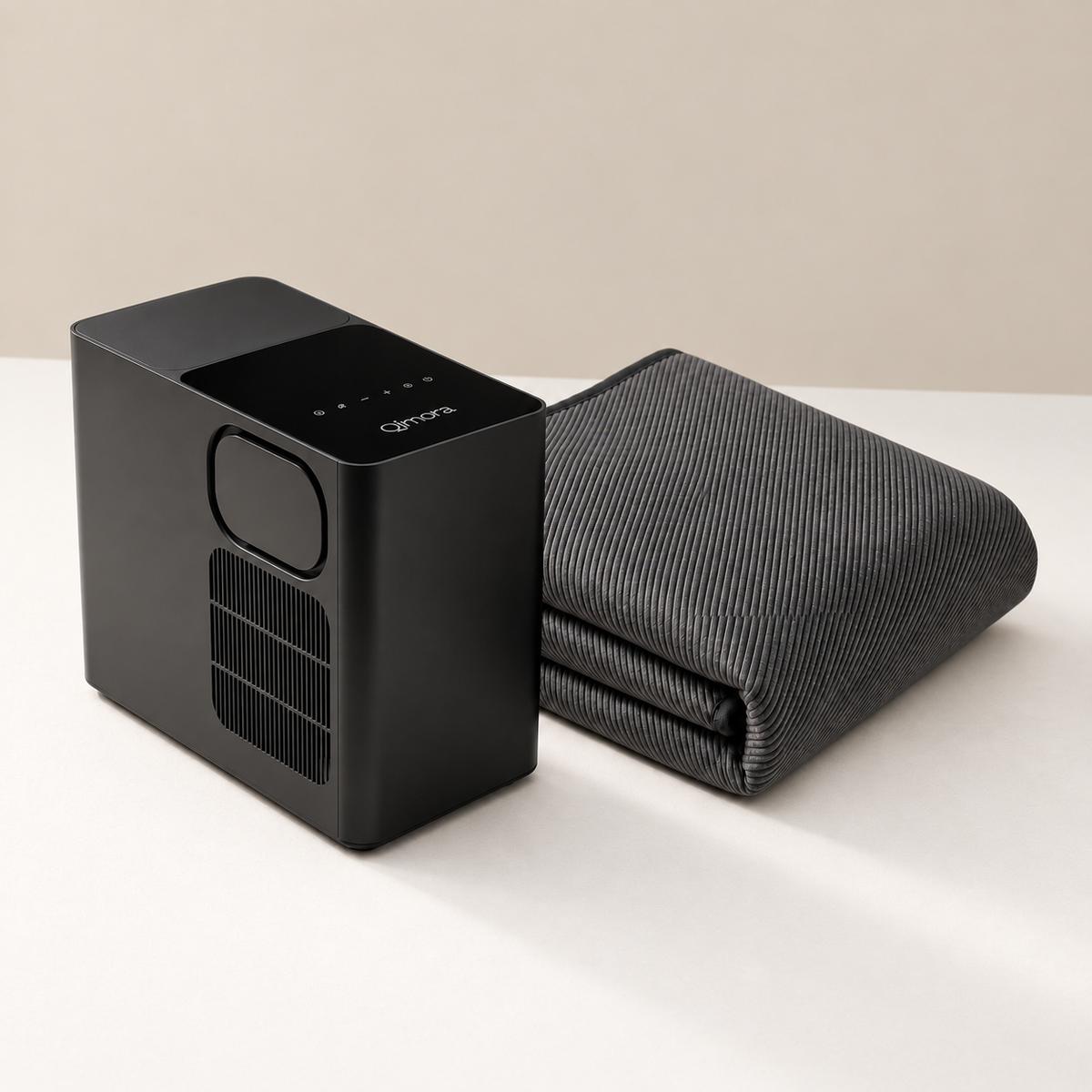 Qimora Sleep Core in Black: the bedside Unit next to the folded Pad