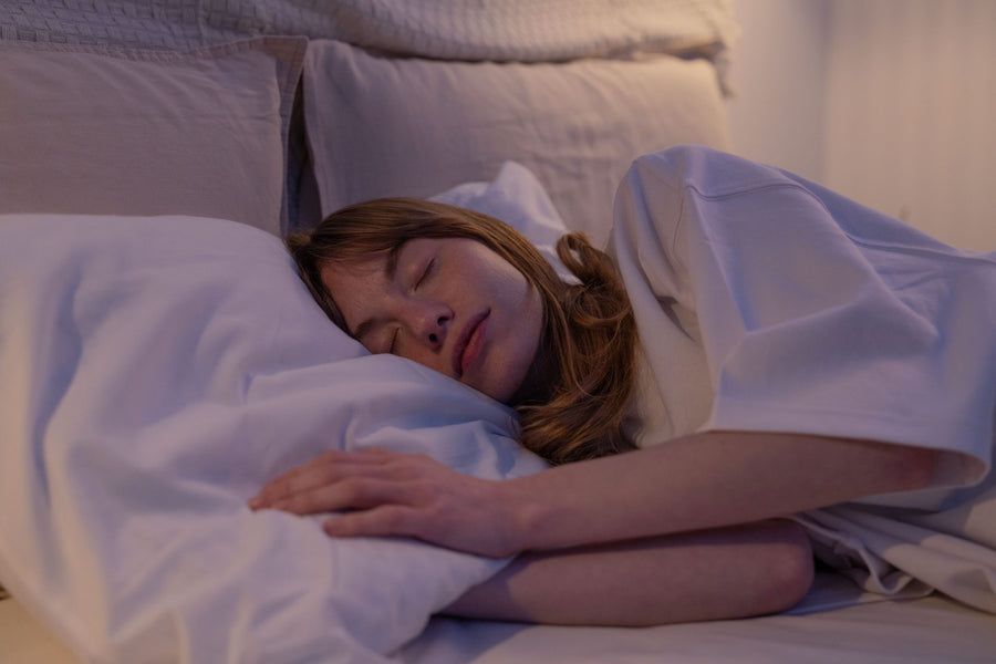 A woman fast asleep in a dim bedroom
